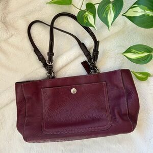 Coach berry-colored pebbled leather handbag with two handles, zipper closure